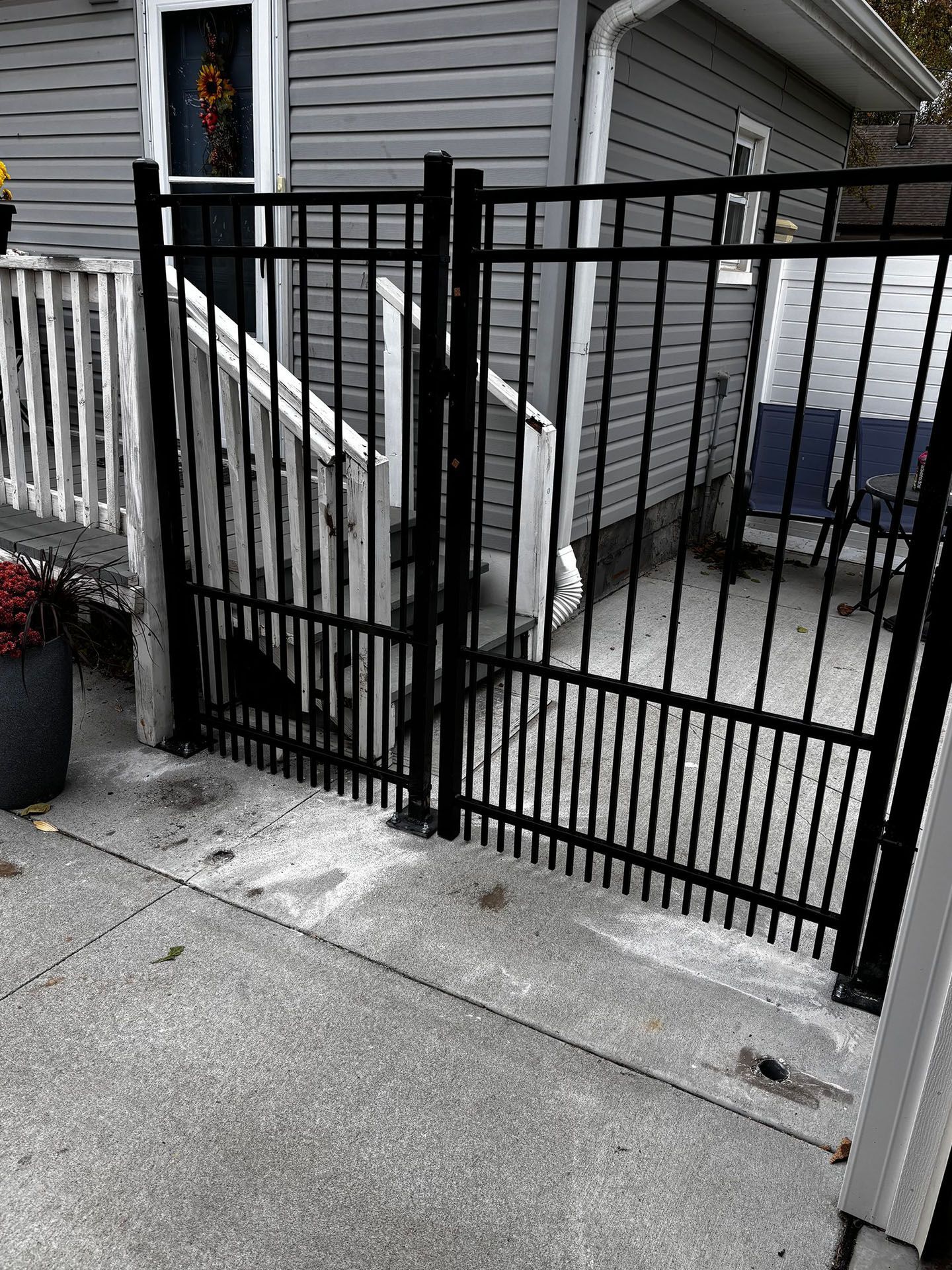 A black metal gate is sitting in front of a house.