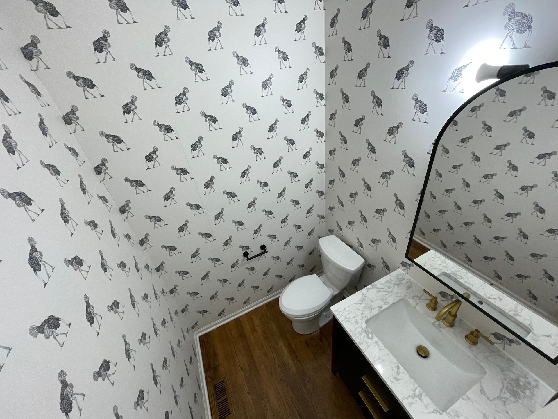 A bathroom with a toilet, sink, and mirror