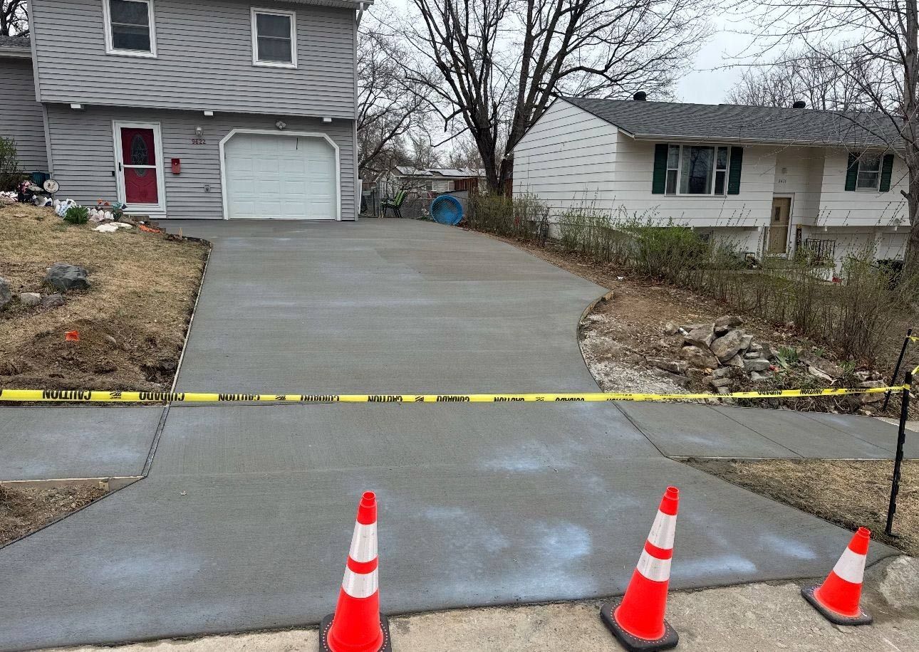 A concrete driveway is being built in front of a house.