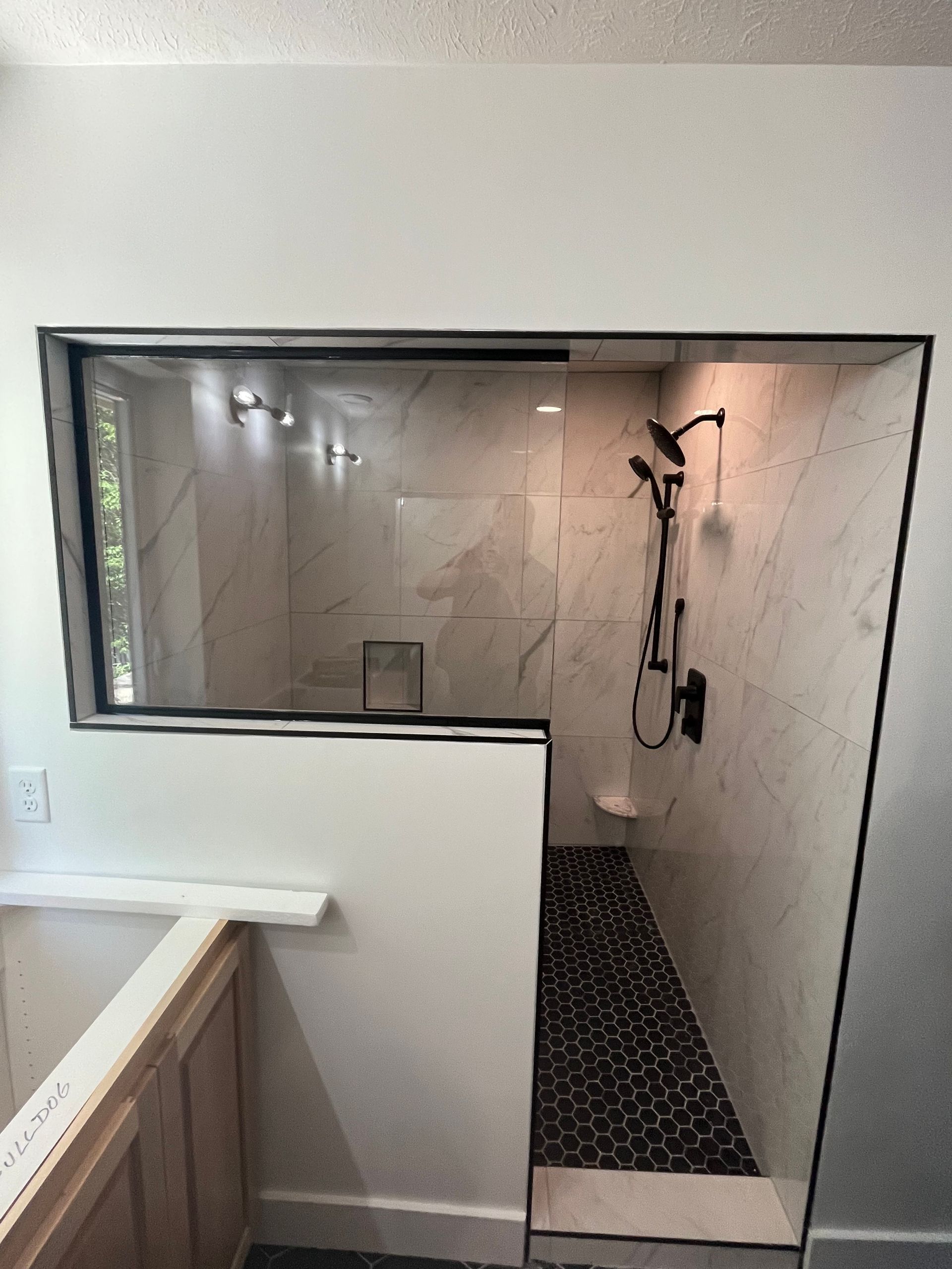 A bathroom with a walk in shower and a window