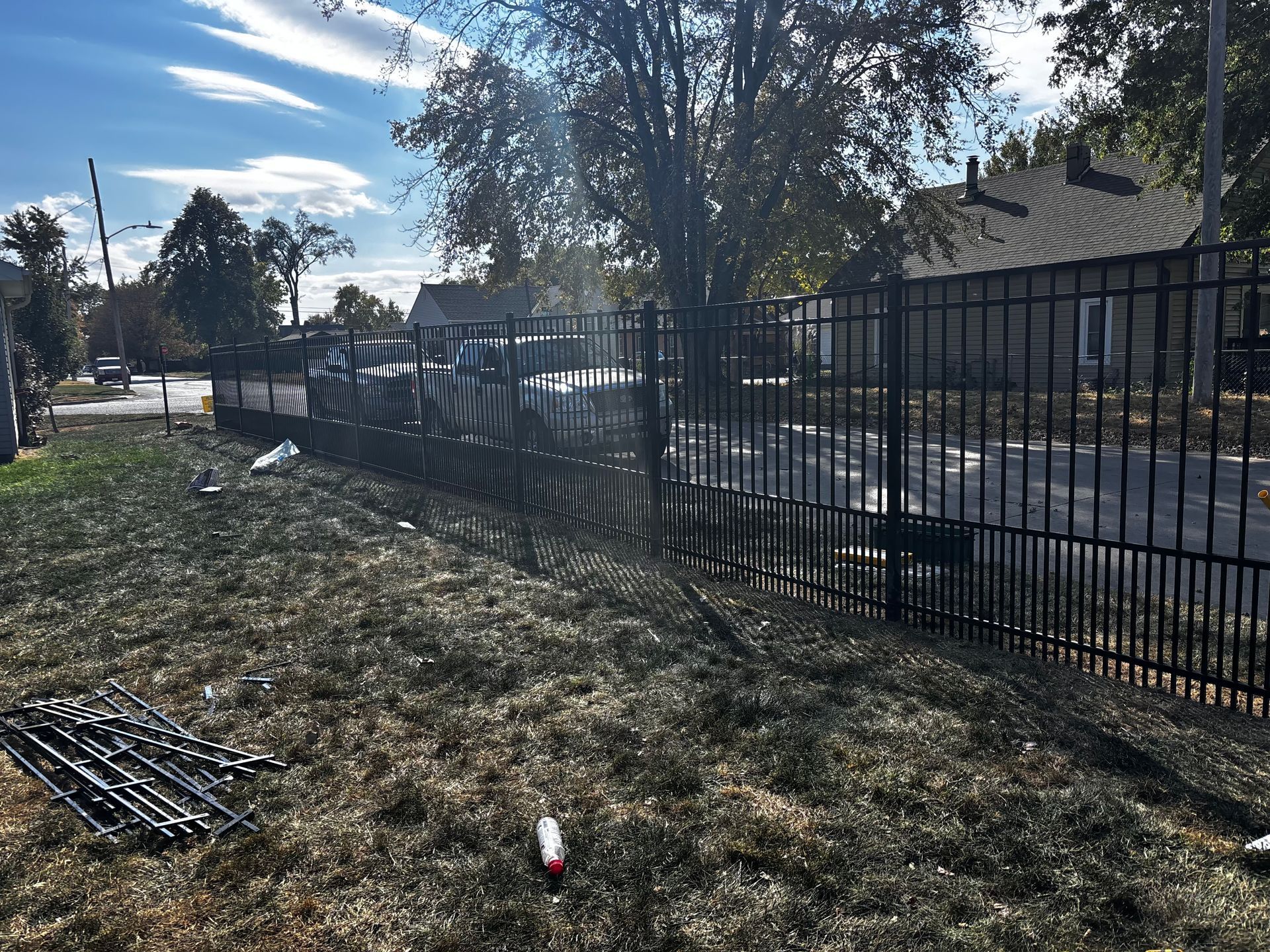 A metal fence is sitting in the middle of a grassy field.