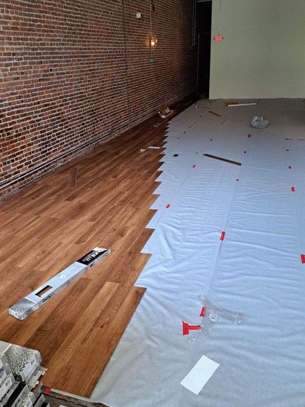 A room with a wooden floor and a brick wall.