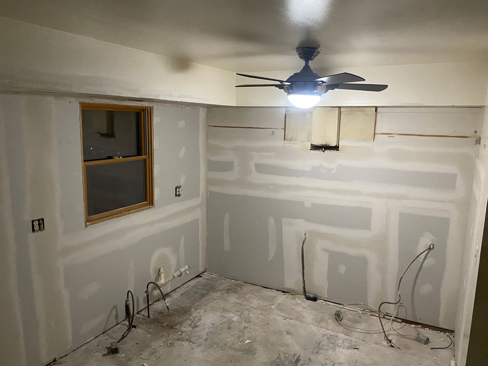 A room with a ceiling fan and a window.