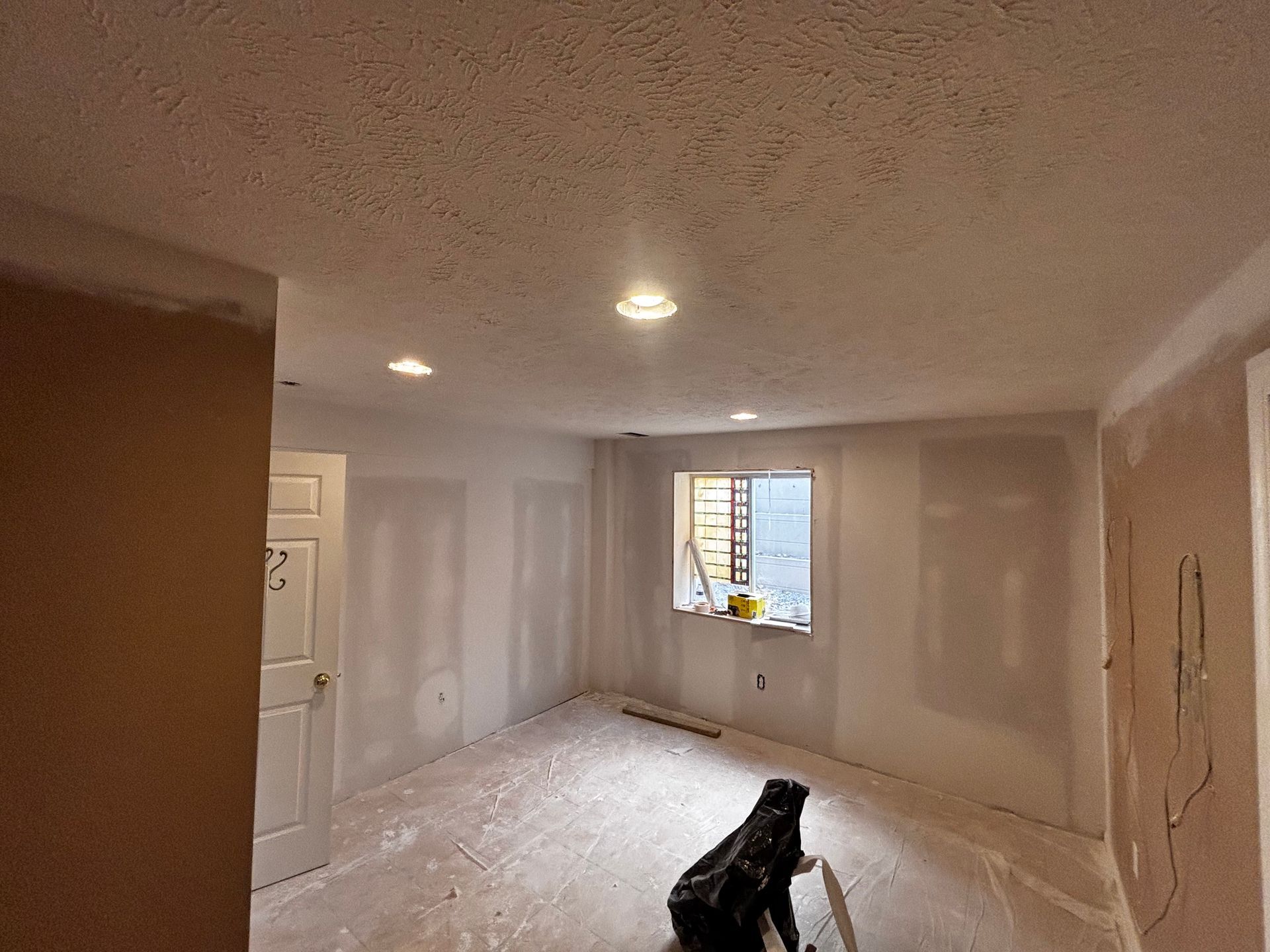 A room with drywall on the walls and a window.