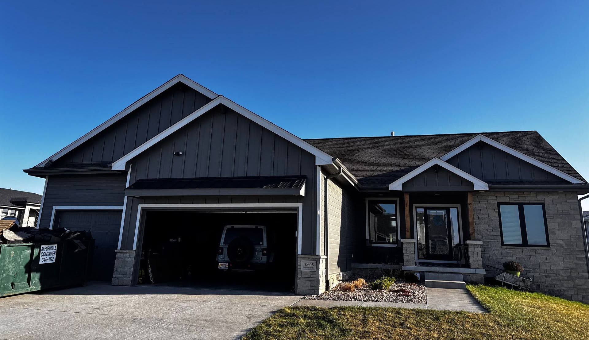 A large house with a large garage and a blue sky in the background.