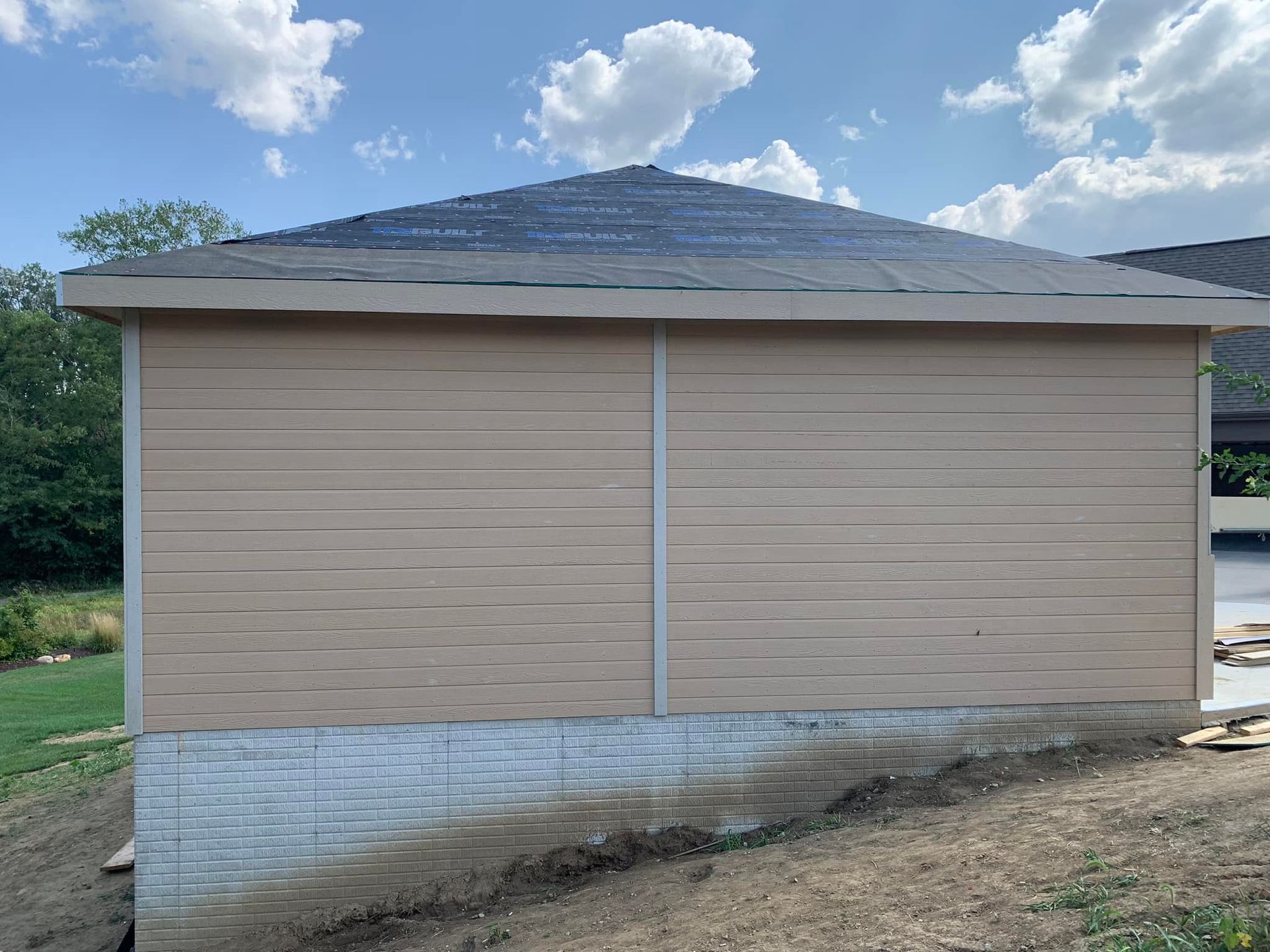 A small house with a roof is sitting on top of a hill.