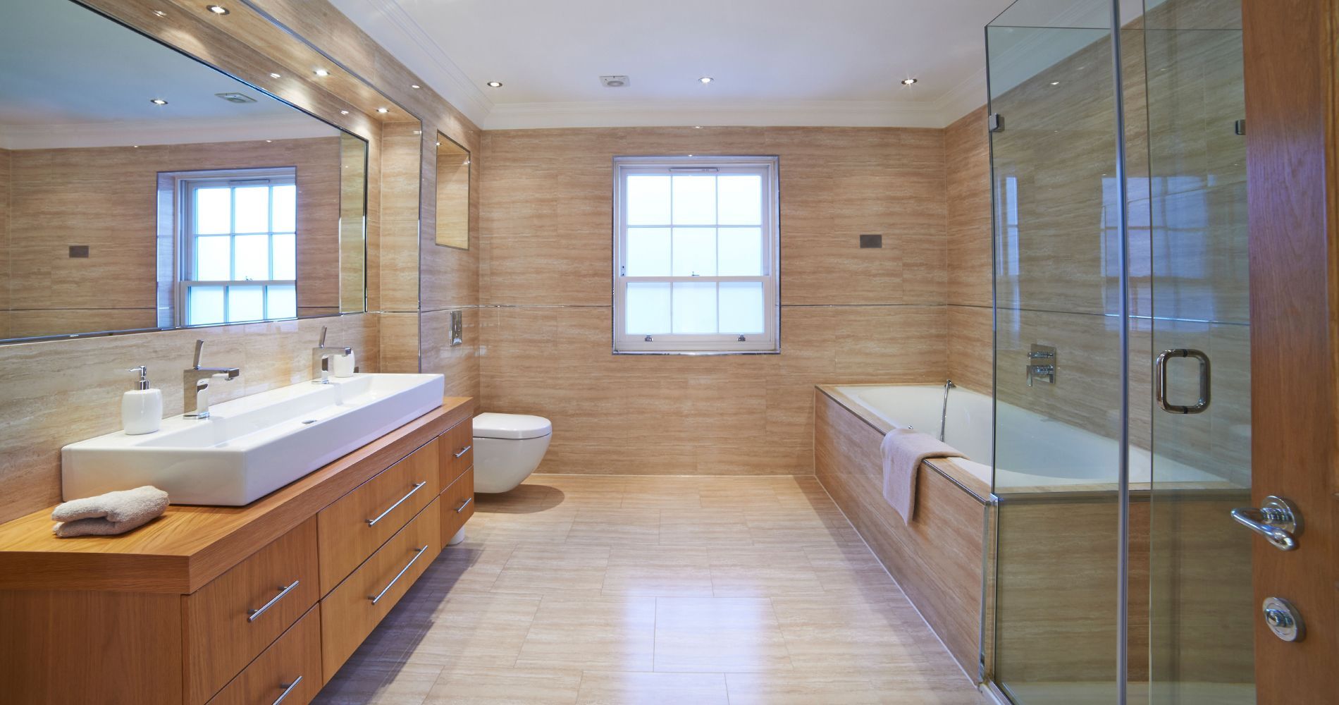 A bathroom with two sinks , a toilet , and a bathtub.