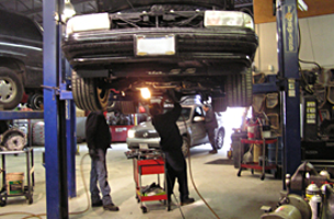 Mechanics repairing auto