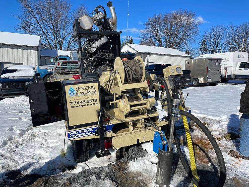 A machine is sitting in the snow in a parking lot.