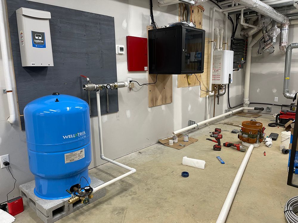 A blue water tank is sitting on top of a concrete floor in a room.