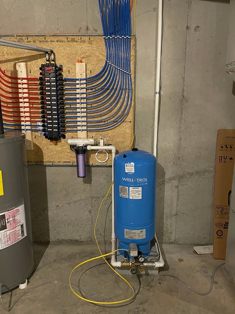 A water tank is sitting in a basement next to a water heater.
