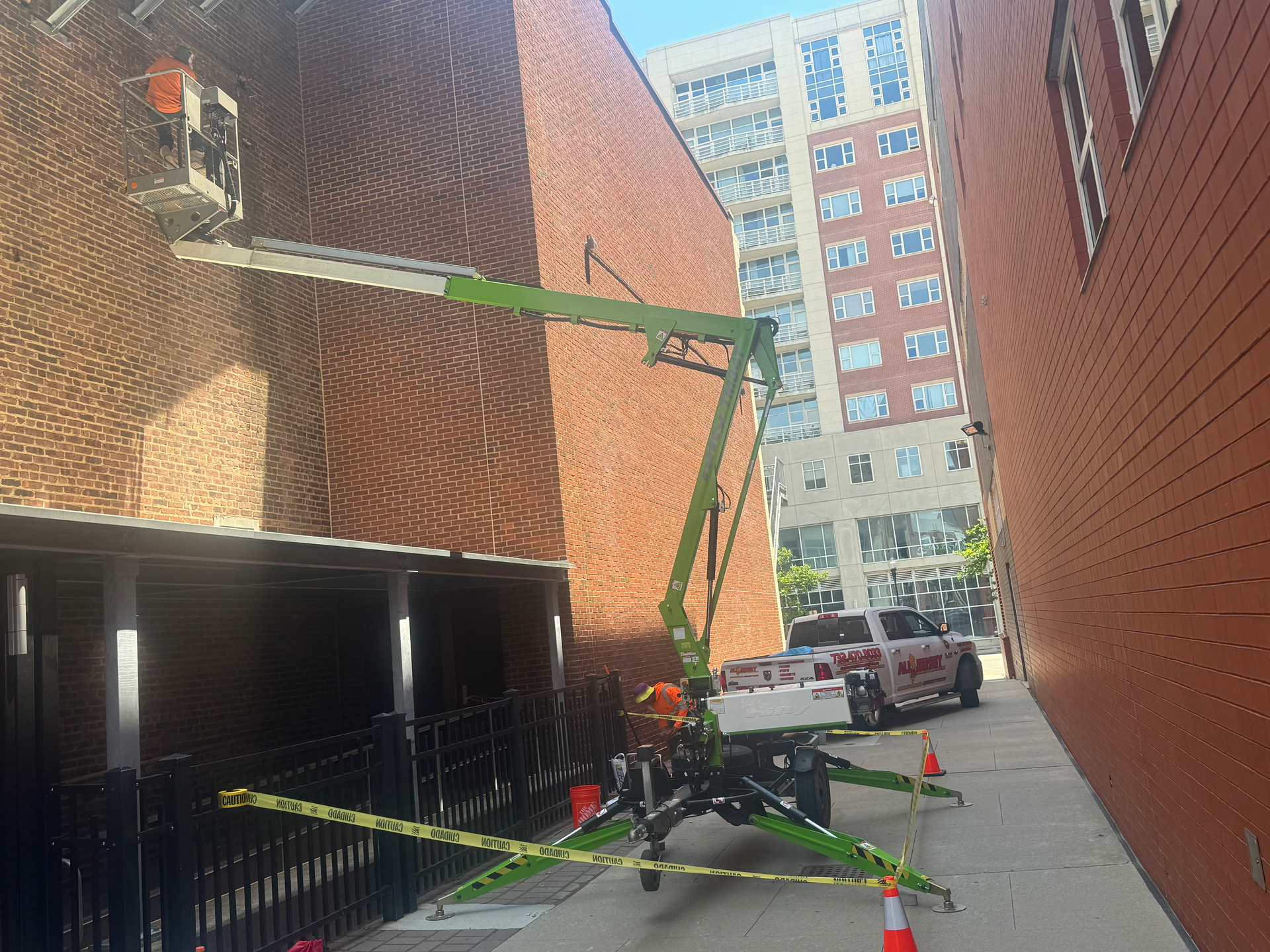 A man is working on a brick wall with a lift.