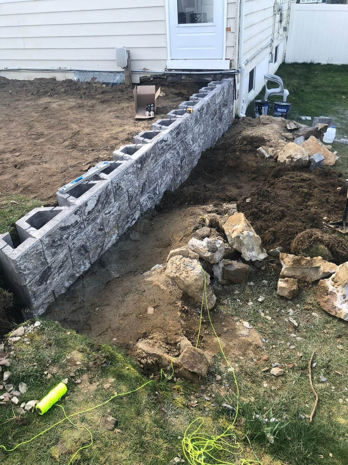 A brick wall is being built in front of a house.
