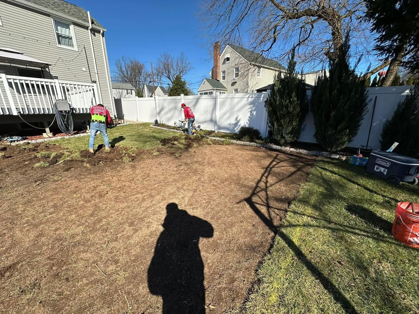 A group of people are working in a backyard.