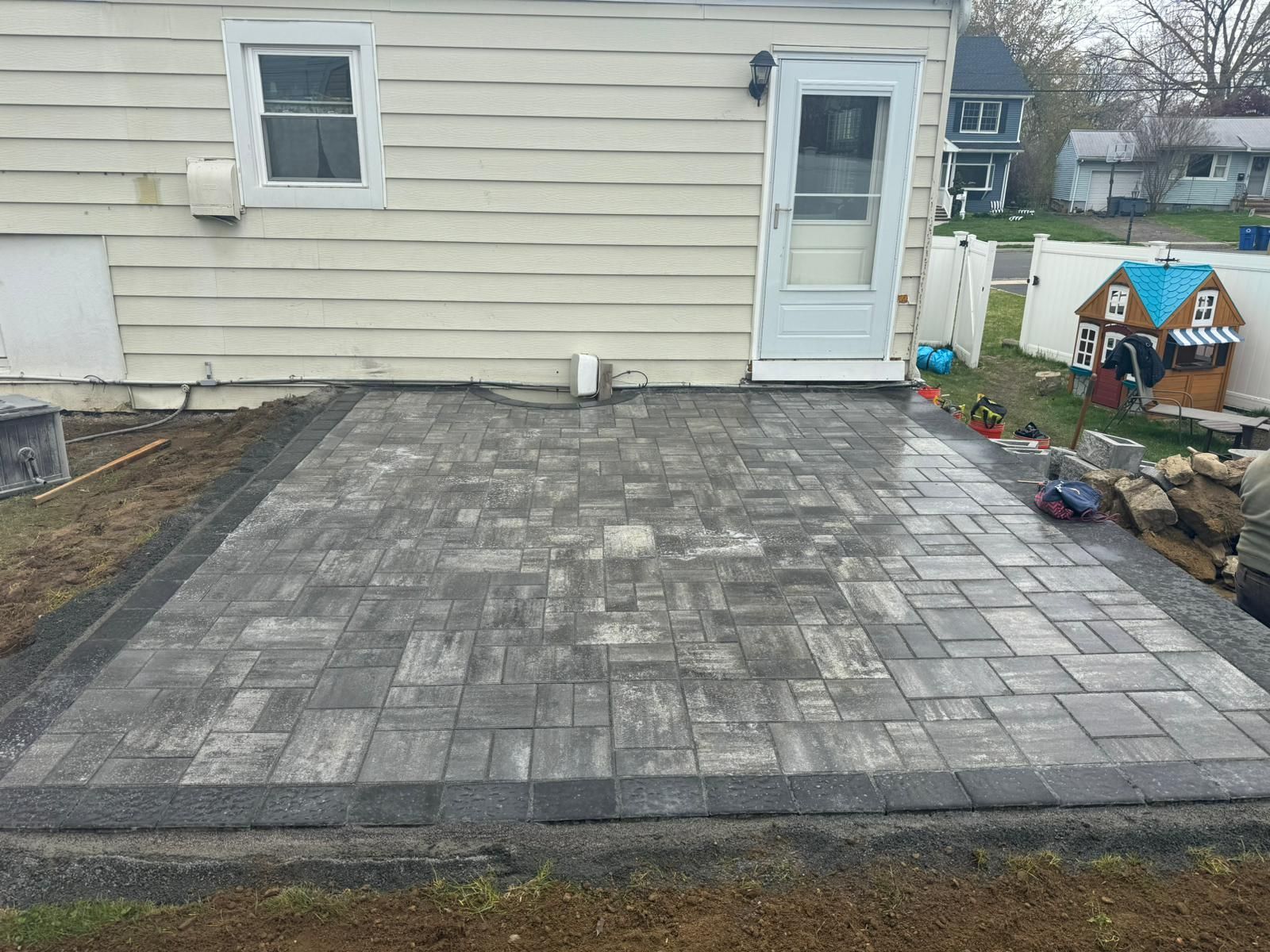 A patio is being built in front of a house.