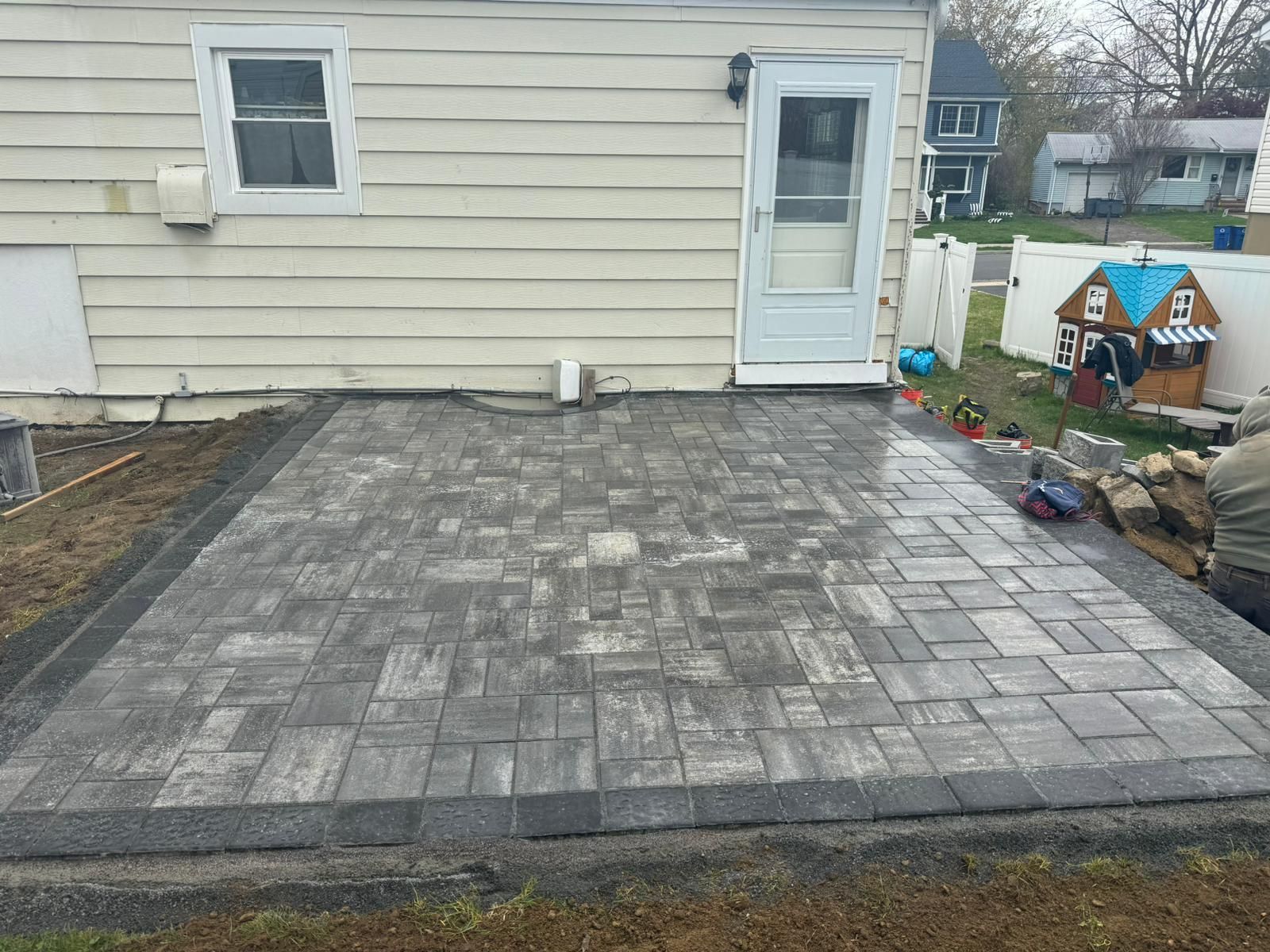 A patio is being built in front of a house.