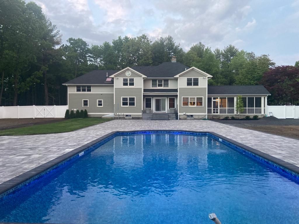 A large house with a large swimming pool in front of it