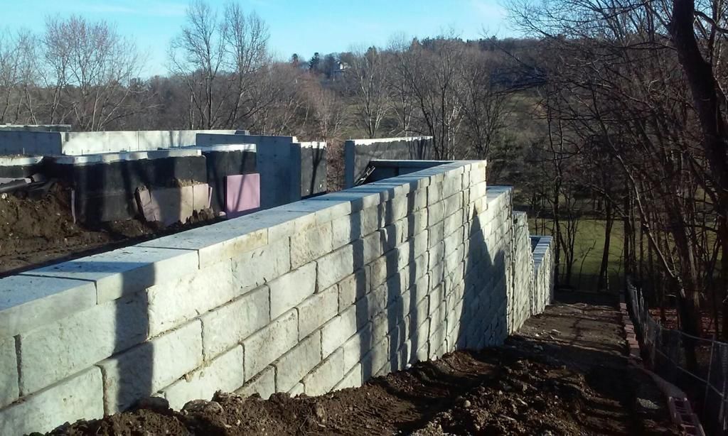 A brick wall is being built in the middle of a forest