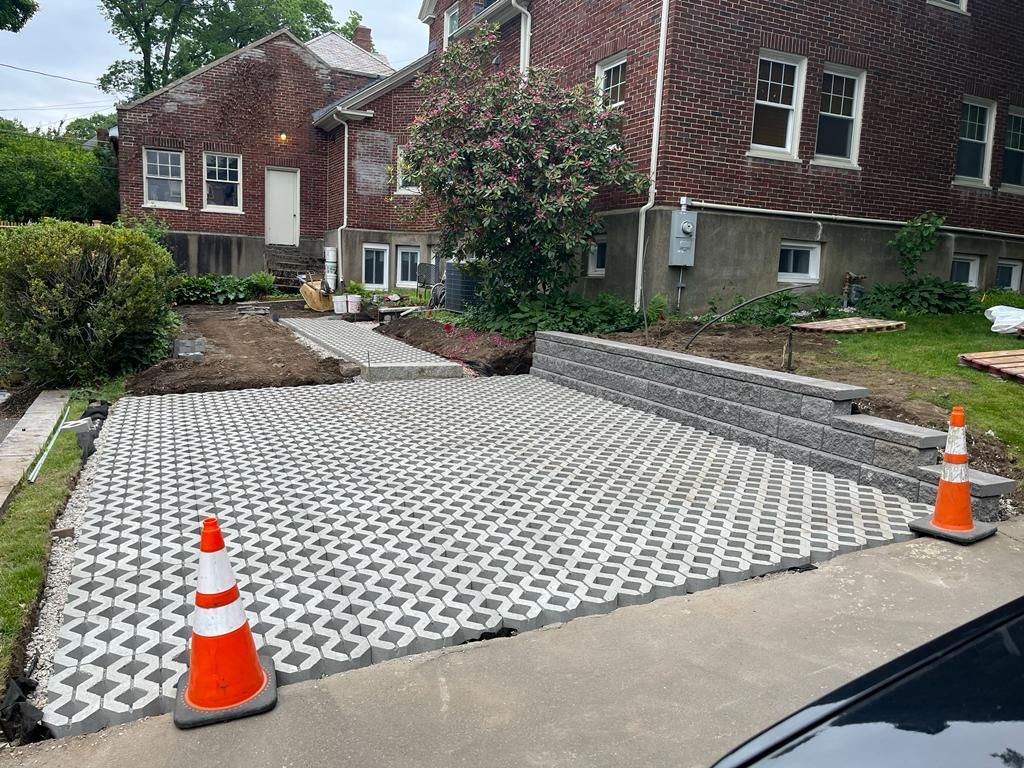 A driveway is being built in front of a brick house.