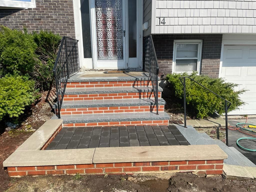 A set of brick steps leading up to the front door of a house