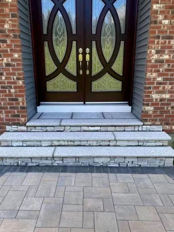 A brick building with a door and steps in front of it.