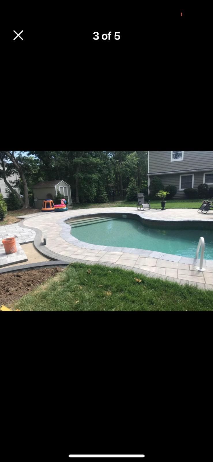 A large swimming pool is being built in a backyard.