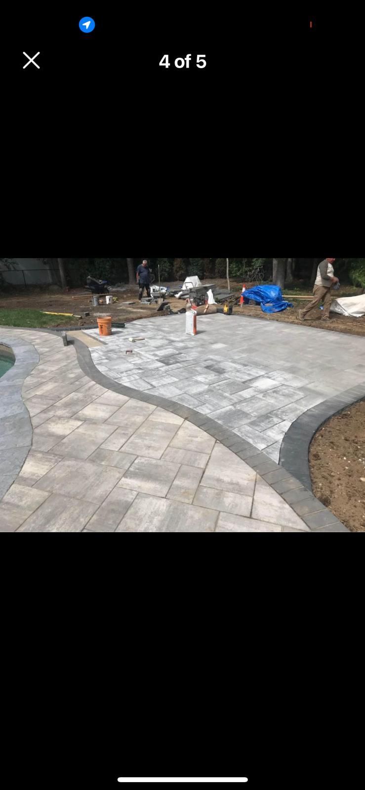 A picture of a patio being built next to a pool.