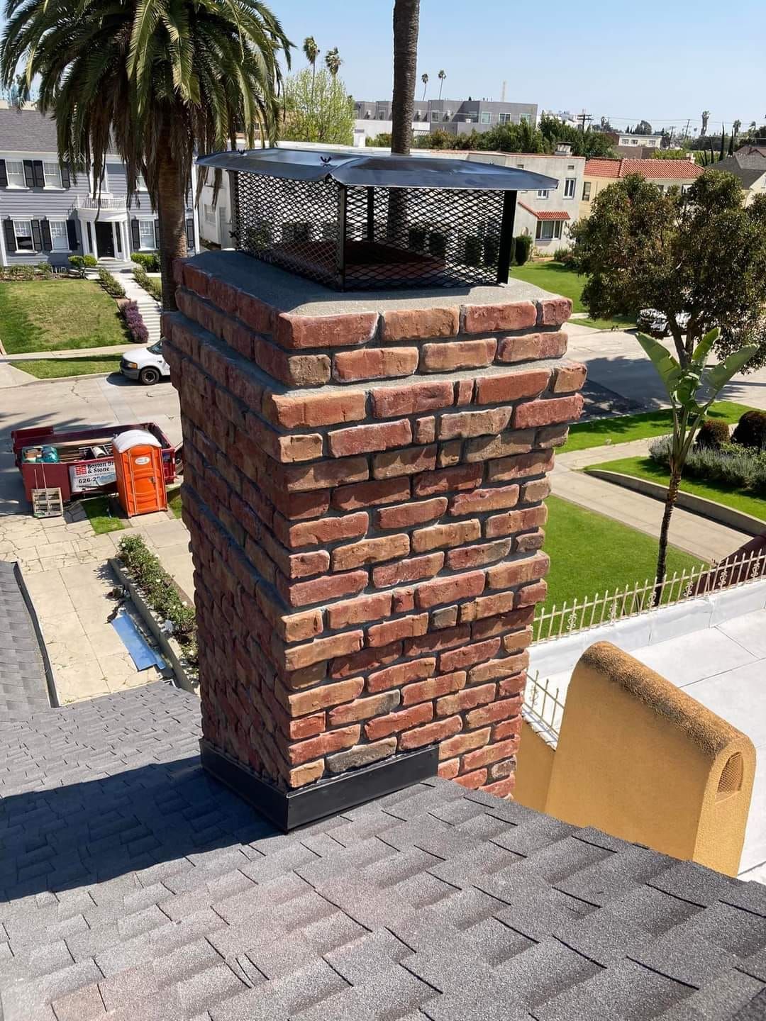 A brick chimney is sitting on top of a roof.