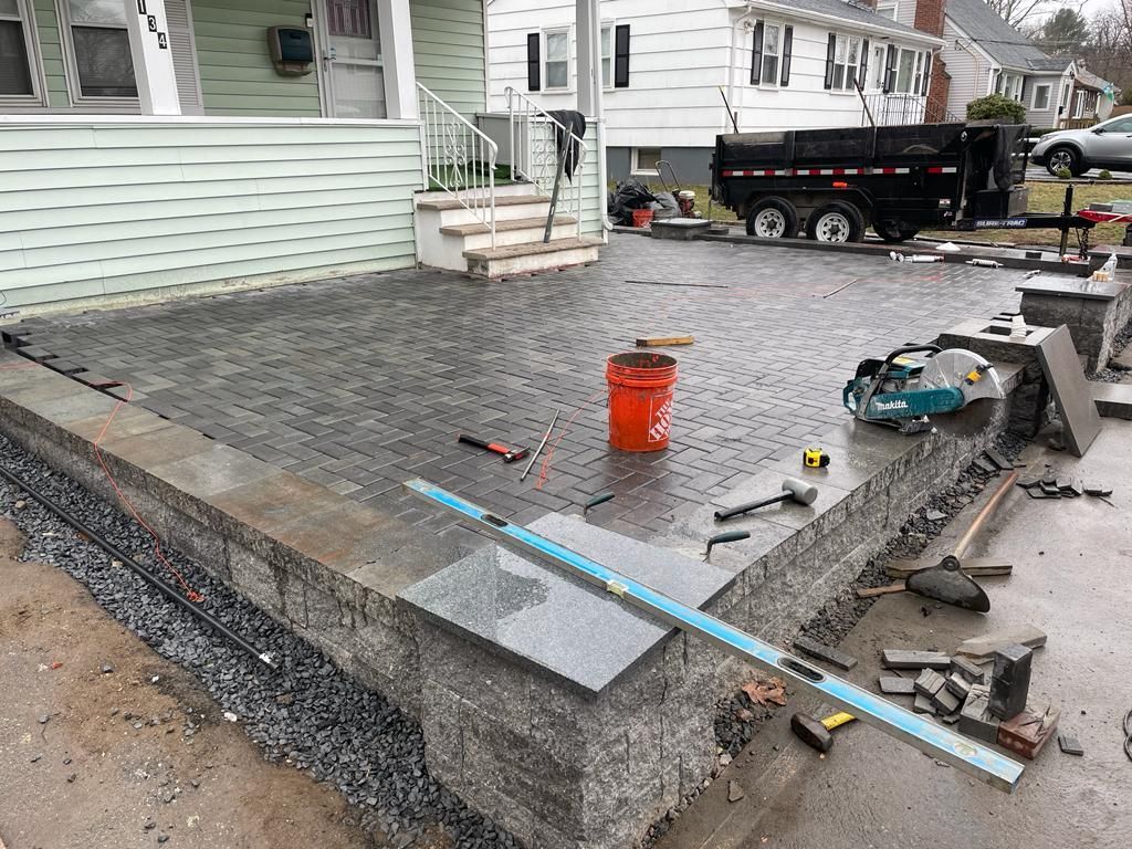 A concrete patio is being built in front of a house.