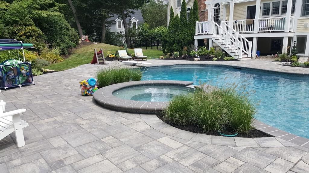 There is a large swimming pool in the backyard of a house.