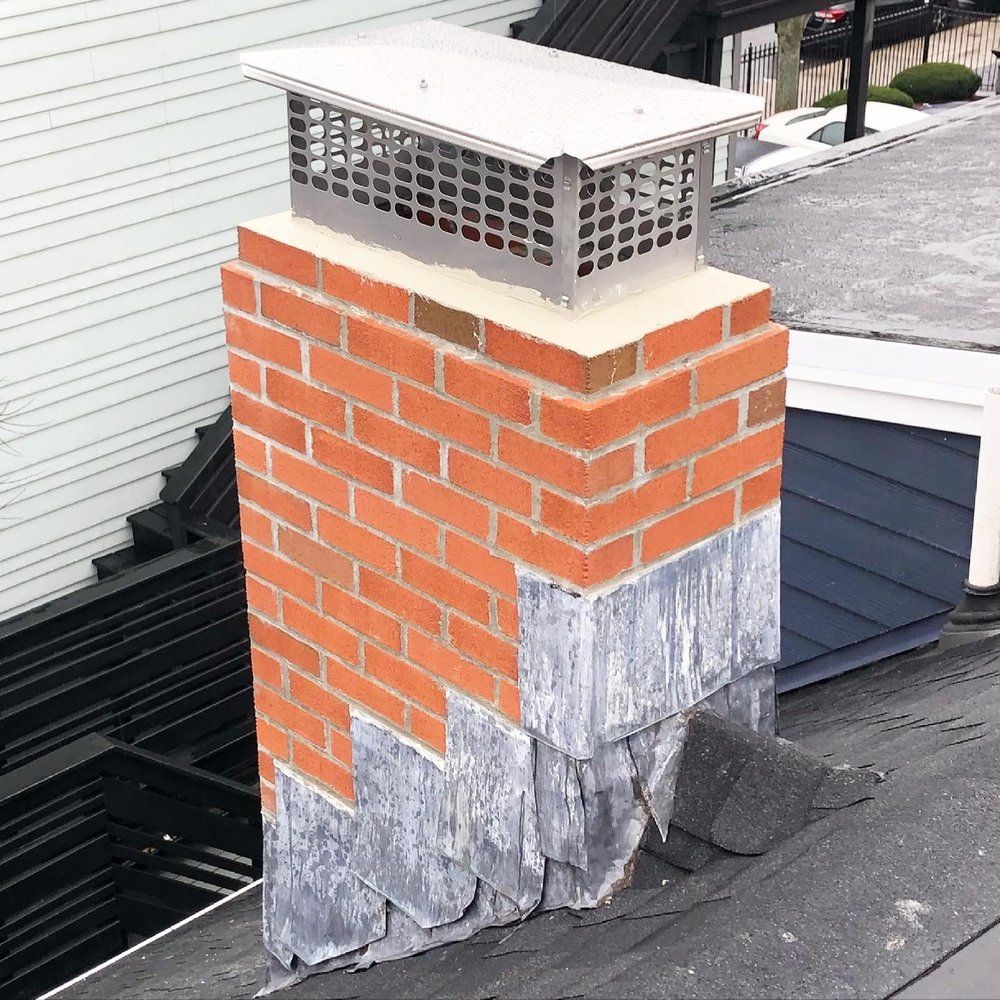 A brick chimney is sitting on top of a roof.