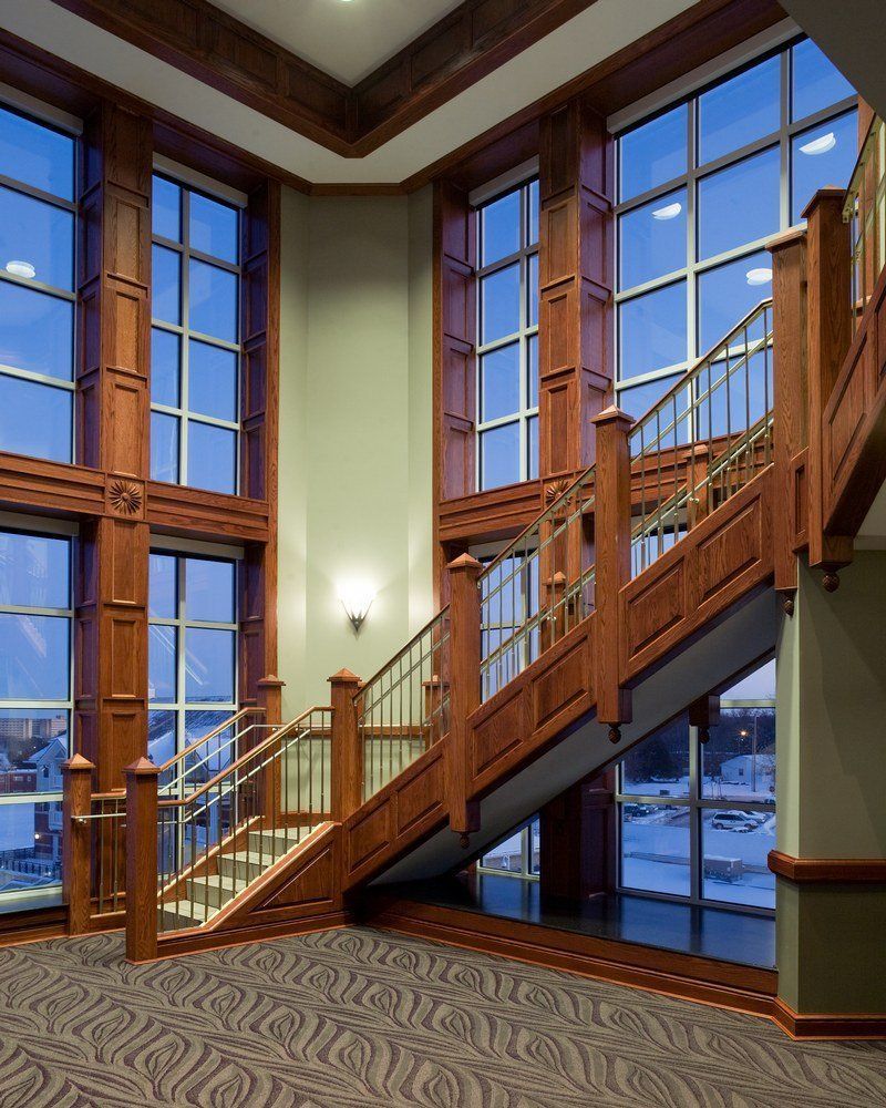 A wooden staircase in a building with lots of windows