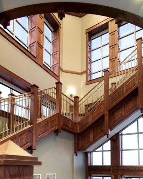 A wooden staircase in a building with lots of windows