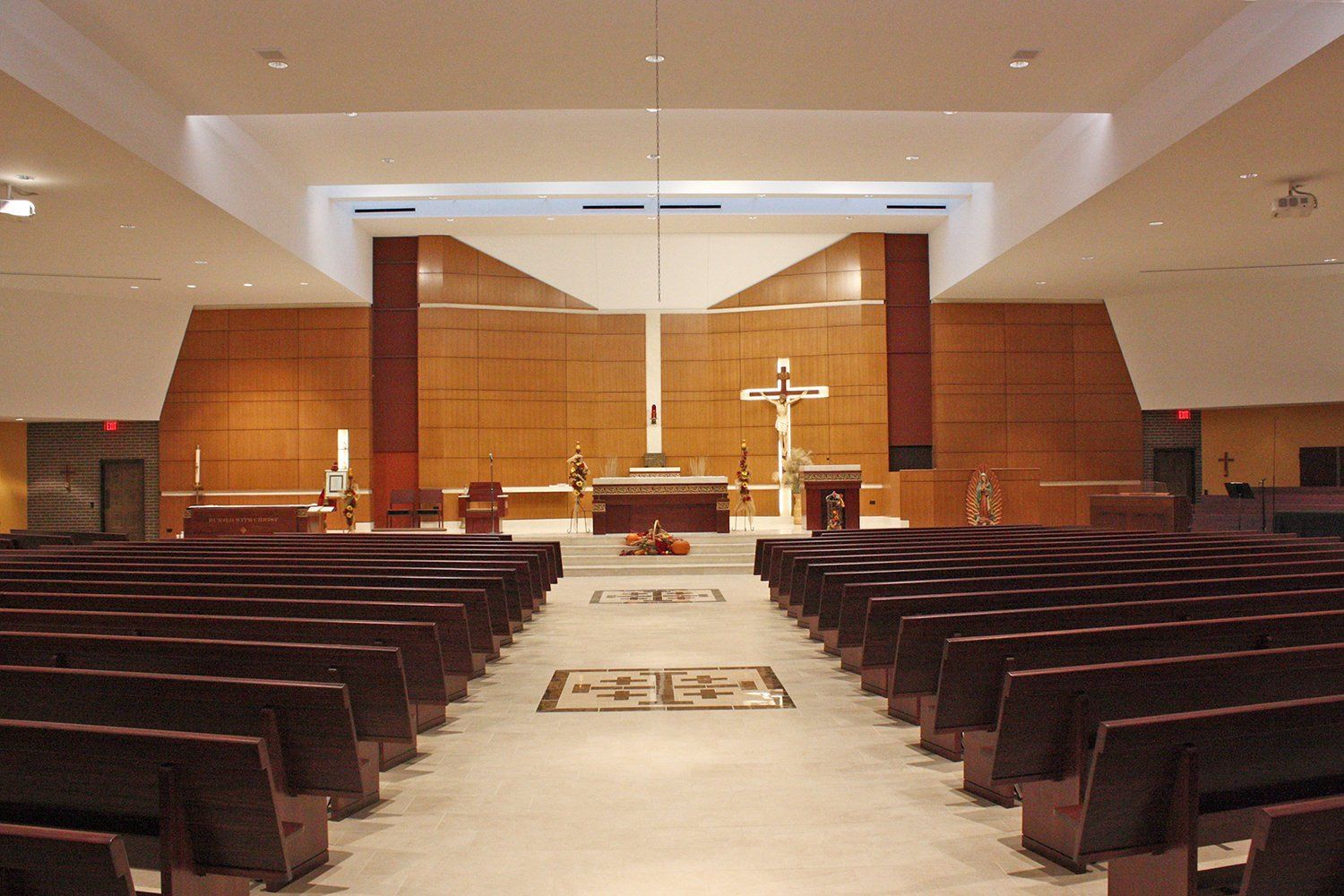 An empty church with rows of pews and a cross on the altar
