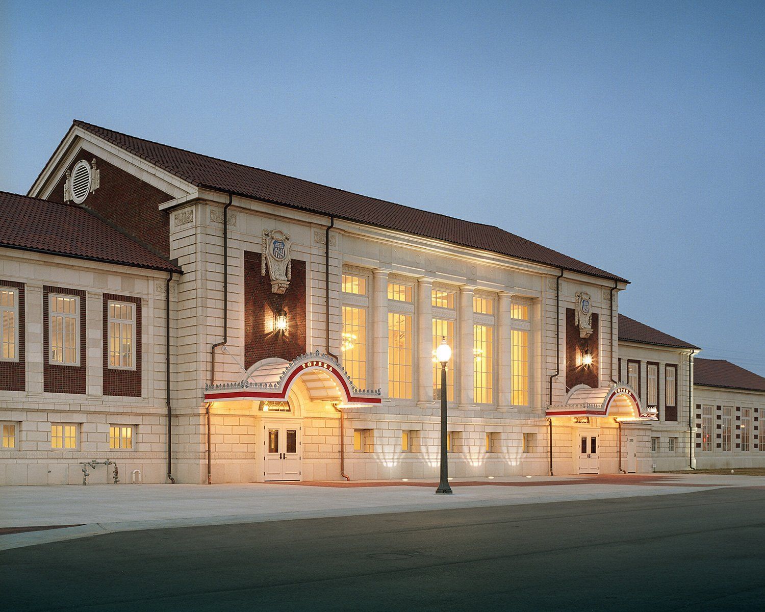 A large white building with a red roof is lit up at night