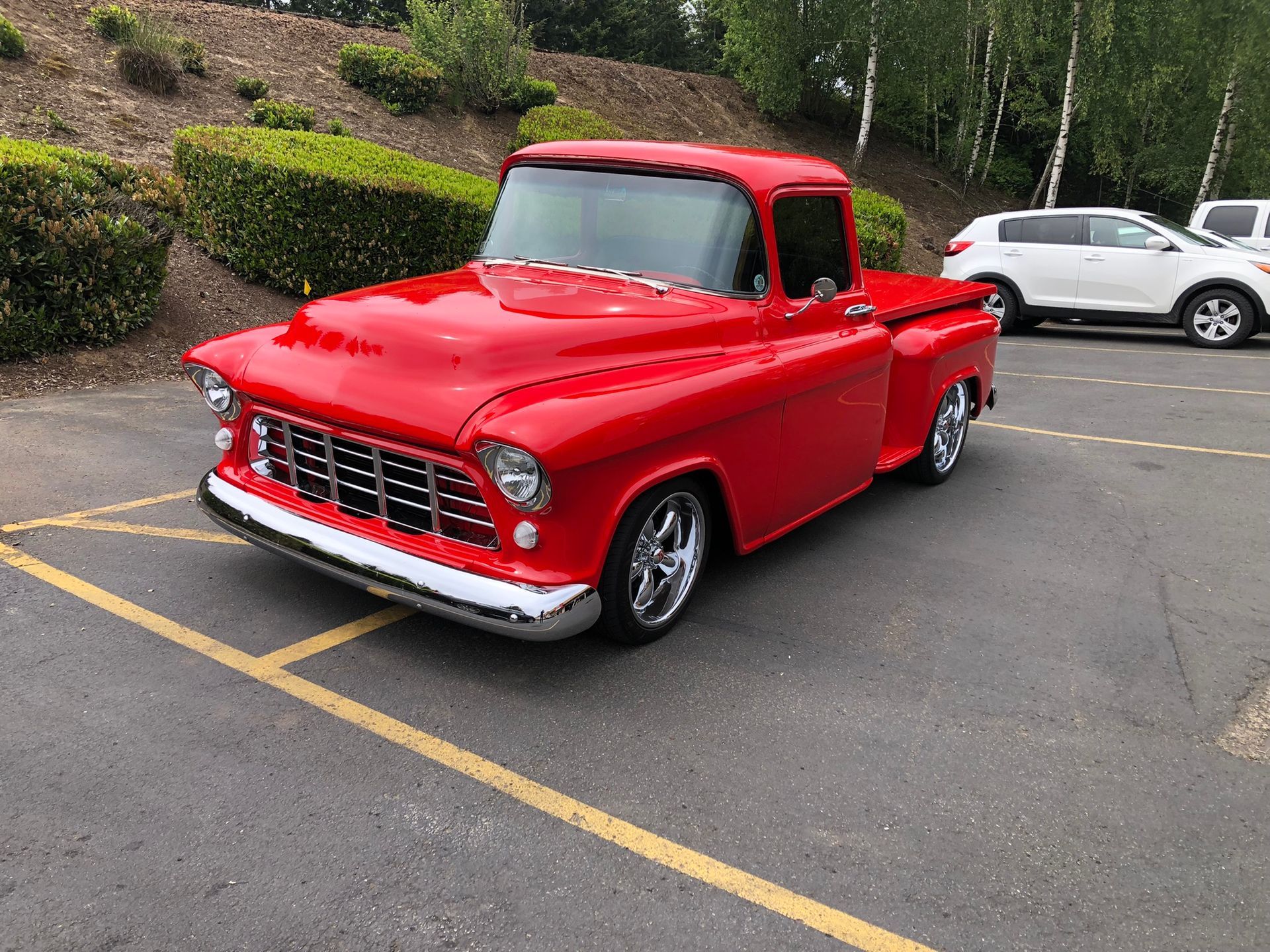 Red classic pickup truck parked in a lot.