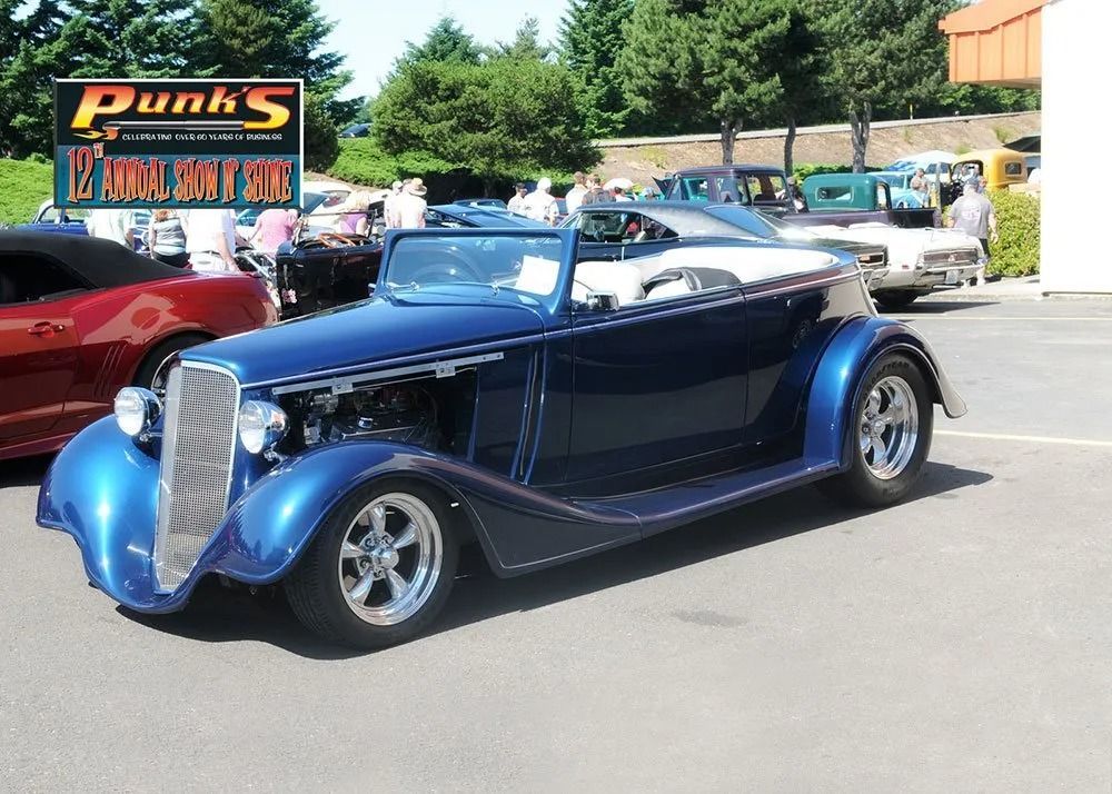 Blue classic convertible car at an outdoor car show.