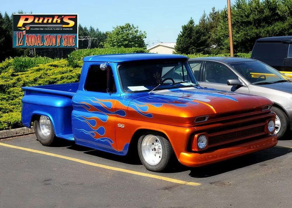 Blue and orange custom Chevrolet pickup truck with flame design parked at Punk's Pit Stop.