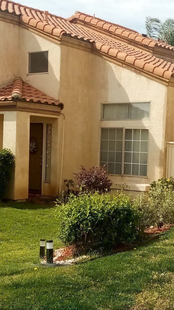 A house with a tiled roof and a lawn in front of it