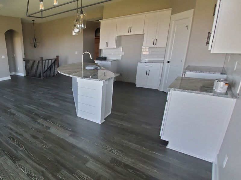 Newly installed hardwood floor with a dark wood border framing the lighter wooden planks in a room with green walls.
