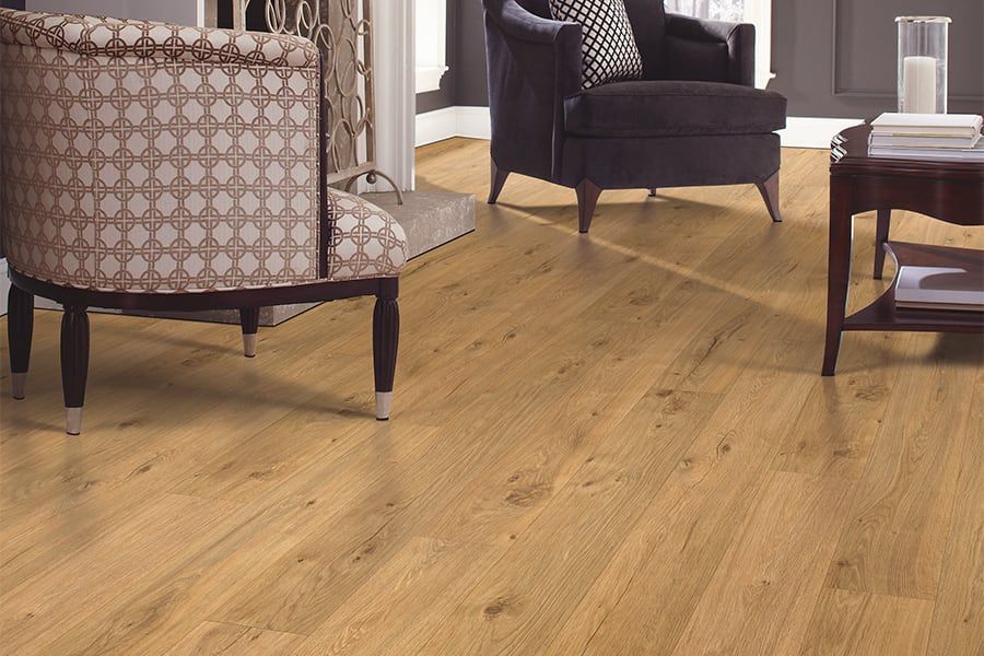A living room with hardwood floors , chairs , a coffee table and a fireplace.
