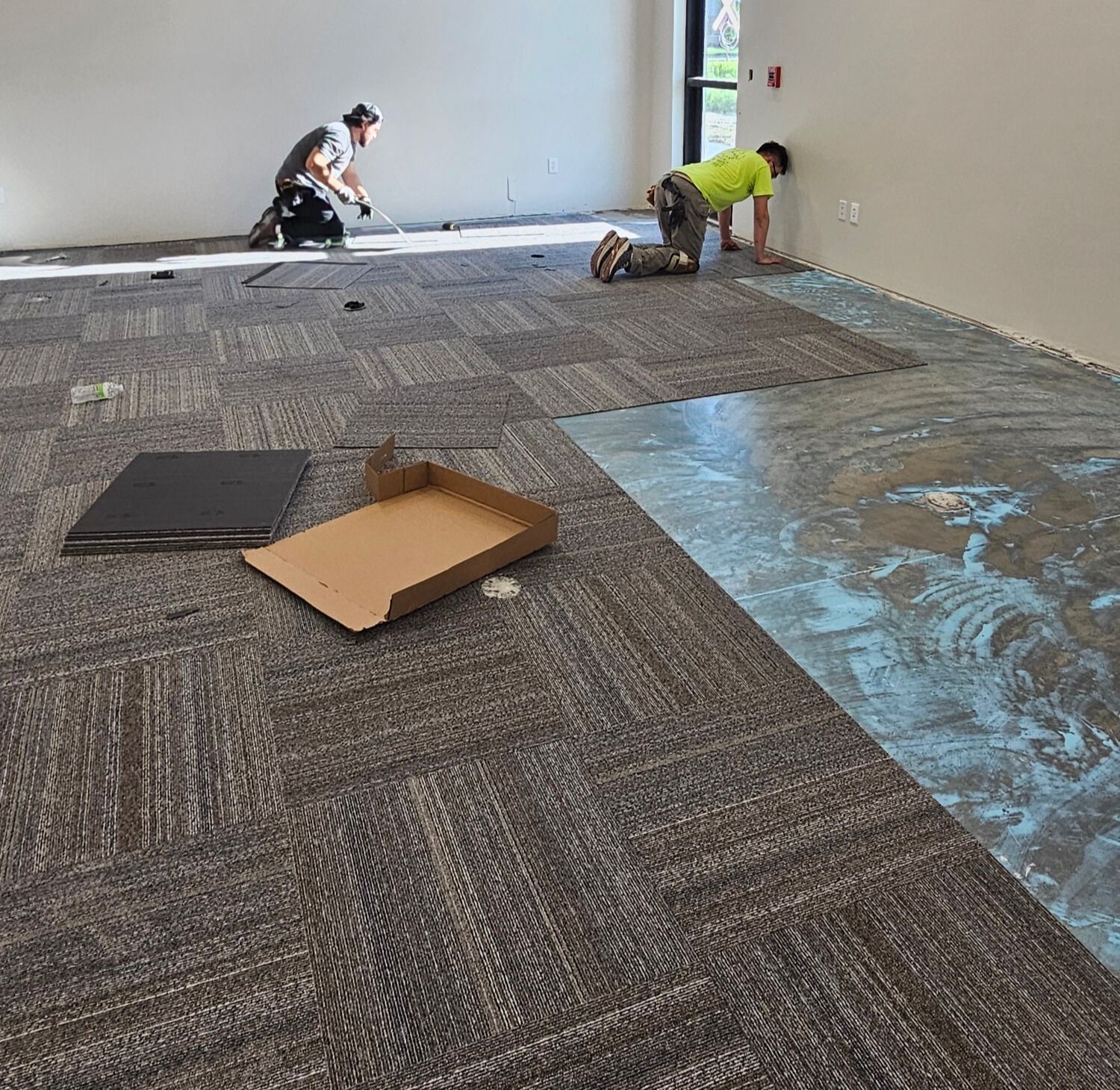 A kitchen with a large island, white cabinets, and dark wood-look flooring.