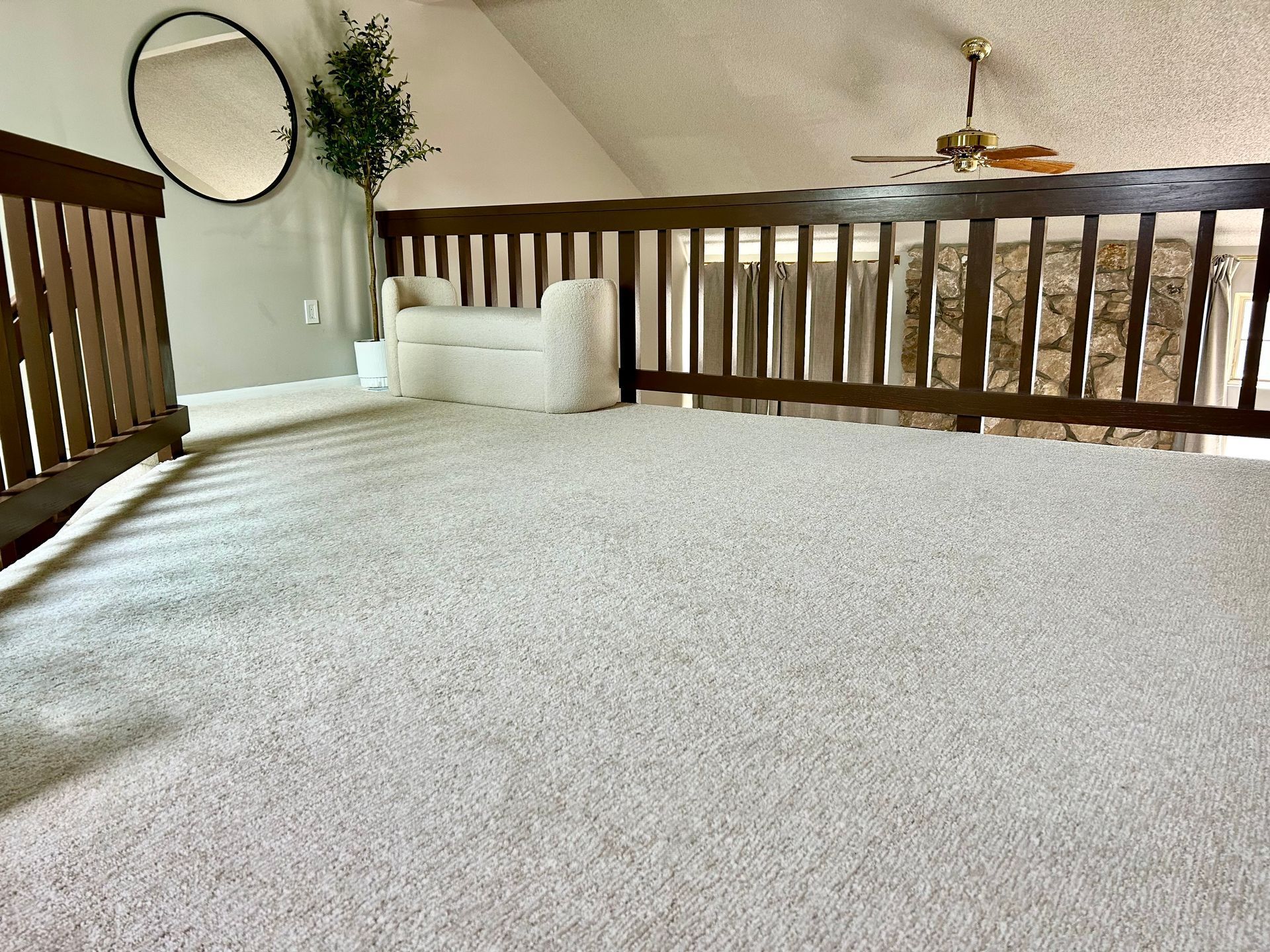 Fireplace surround under construction, tiled with a mosaic of gray and white brick-like tiles. An opening for the firebox is visible.