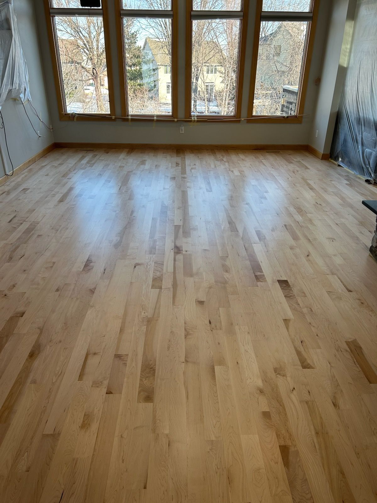 A living room with patterned gray carpet, a brick fireplace, and white walls.