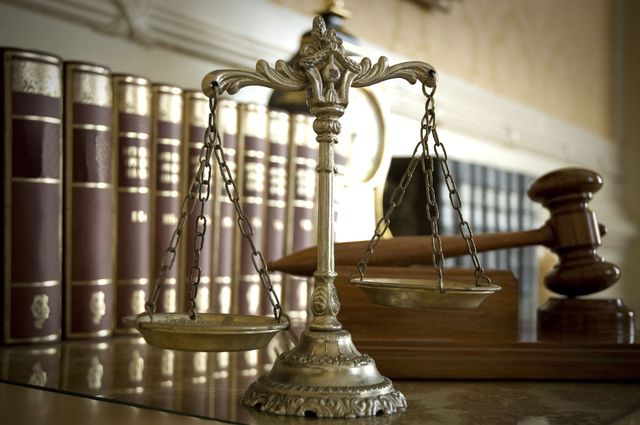 Scales of justice with books and gavel in a law office setting.