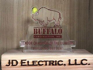 A buffalo construction inc vendor champion of the quarter award is sitting on top of a wooden block.