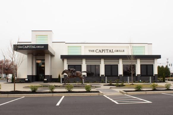 Exterior of The Capital Ale House restaurant with empty parking lot on an overcast day