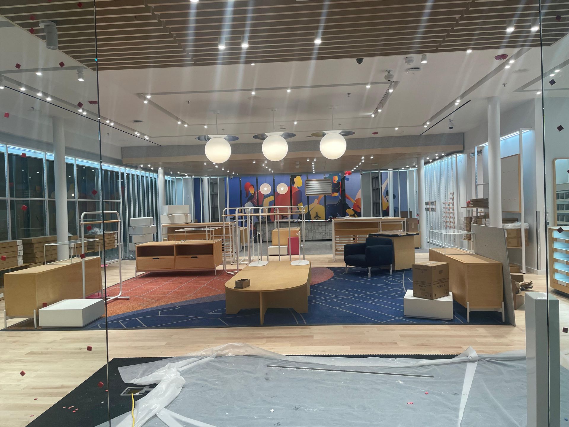 Modern lobby with lounge seating, pendant lights, and glass walls in a spacious office interior