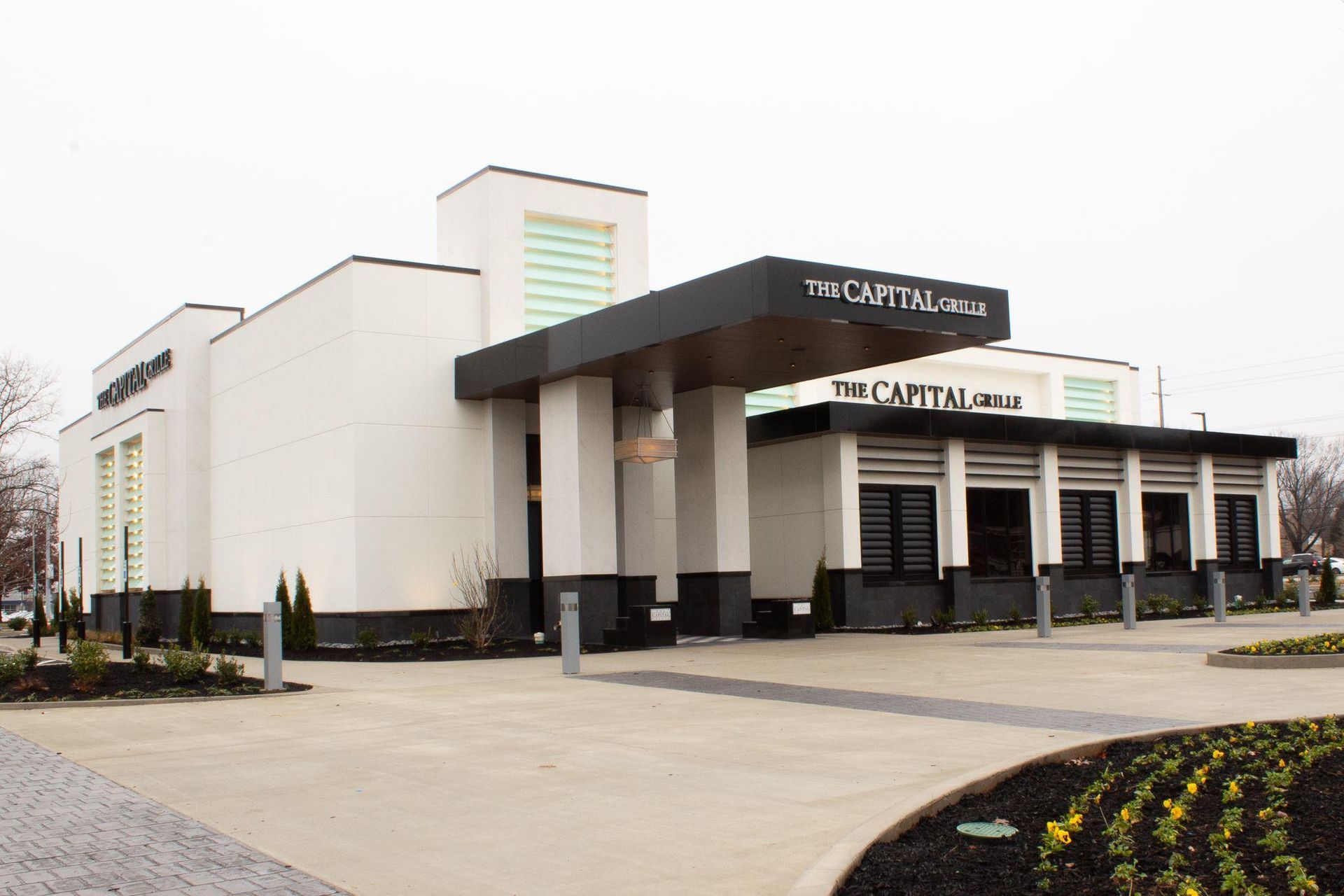Exterior of The Carlton, a modern white building with black accents and a covered entrance.
