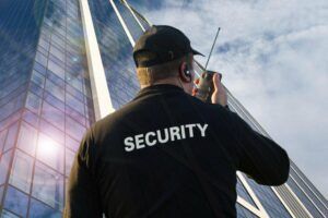 Security guard overlooking an urban area with tall buildings and trees.